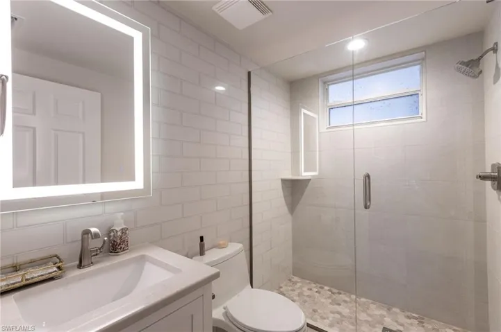 3rd bathroom offers a remodeled walk in shower, single vanity and backlit mirror.