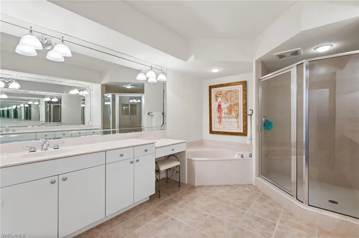 Primary bathroom offers a separate soaking tub, walk in shower, dressing area and two vanities.