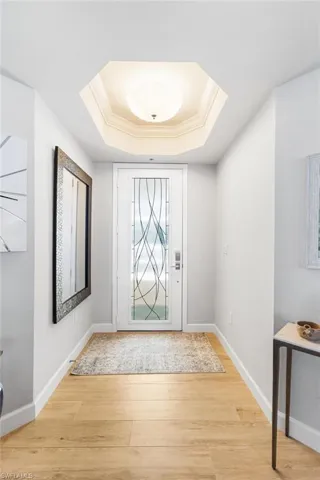 Etched glass front entry door into your foyer with a tray ceiling.