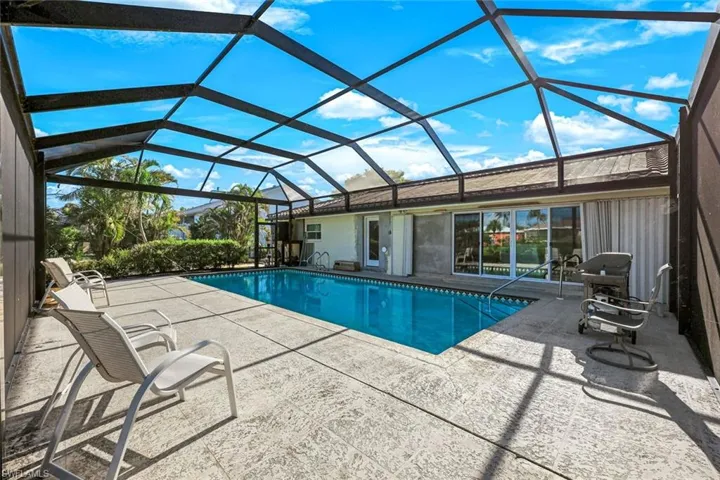 Outdoor pool with glass enclosure and a patio