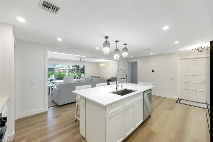 Kitchen featuring open floor plan, light wood-style flooring, white cabinetry, recessed lighting, and light countertops