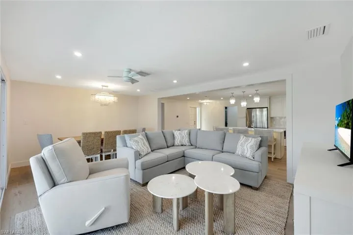 Living room with recessed lighting, light wood-style floors, and a chandelier
