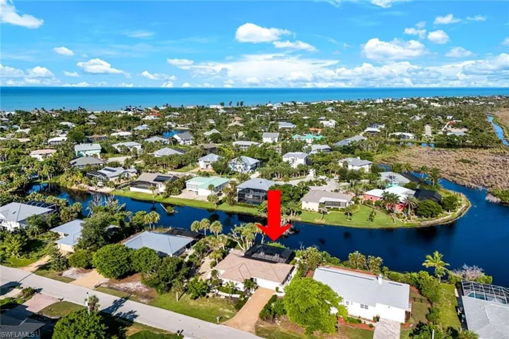 Aerial perspective of suburban area featuring a nearby body of water