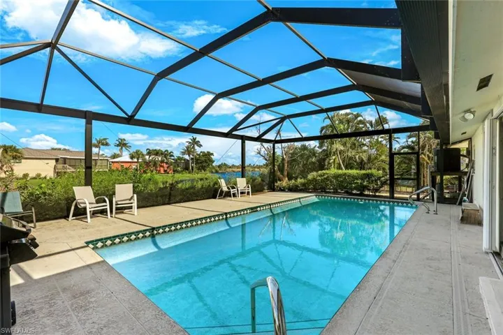 Outdoor pool with a patio and glass enclosure