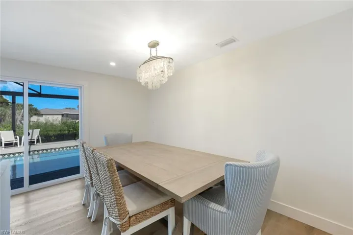 Dining area featuring light wood finished floors, a chandelier, and recessed lighting