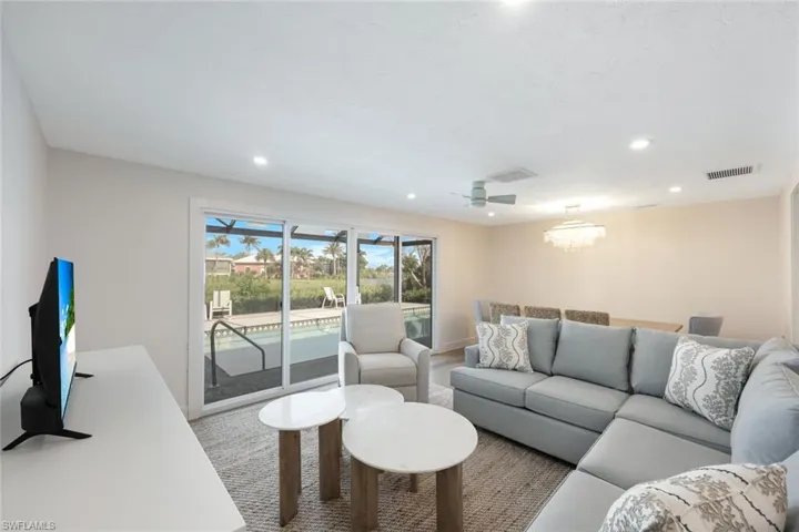 Living area with recessed lighting, ceiling fan, and a chandelier
