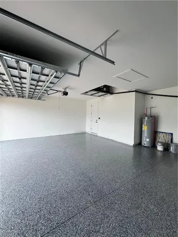 Garage featuring water heater and a garage door opener