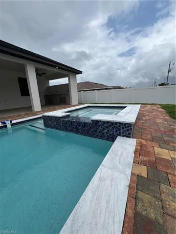 View of pool featuring a patio, an in ground hot tub, and ceiling fan