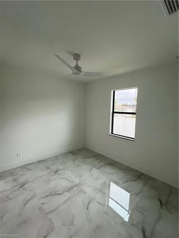 Tiled spare room with ceiling fan