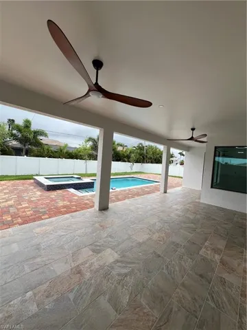 View of swimming pool with a patio area, an in ground hot tub, and ceiling fan