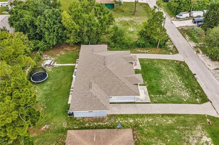 Spacious residential property featuring an asphalt shingle roof, light blue exterior siding, and a concrete driveway