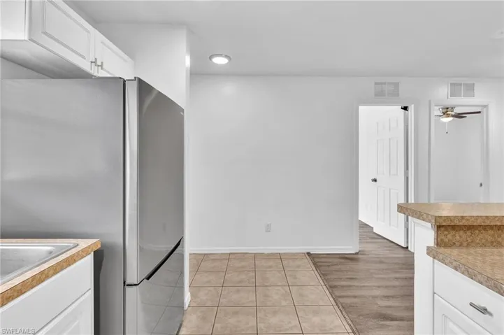 Kitchen area featuring white cabinetry, a stainless steel refrigerator, and a light-colored countertop