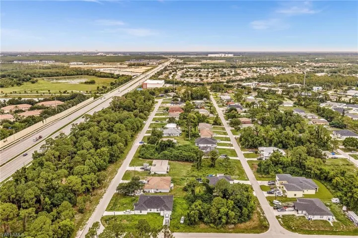 Aerial perspective showcasing a residential area with single-story homes, established trees, and paved streets