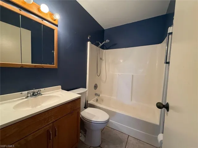 Full bathroom featuring washtub / shower combination, light tile patterned flooring, and vanity