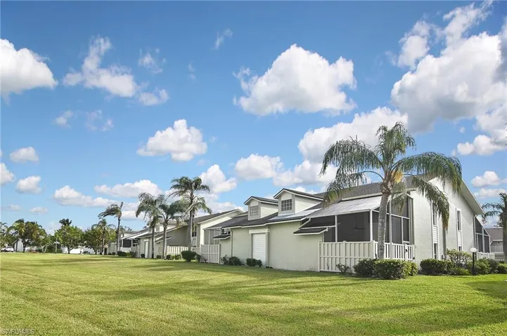 View of side of property featuring a sunroom and a yard