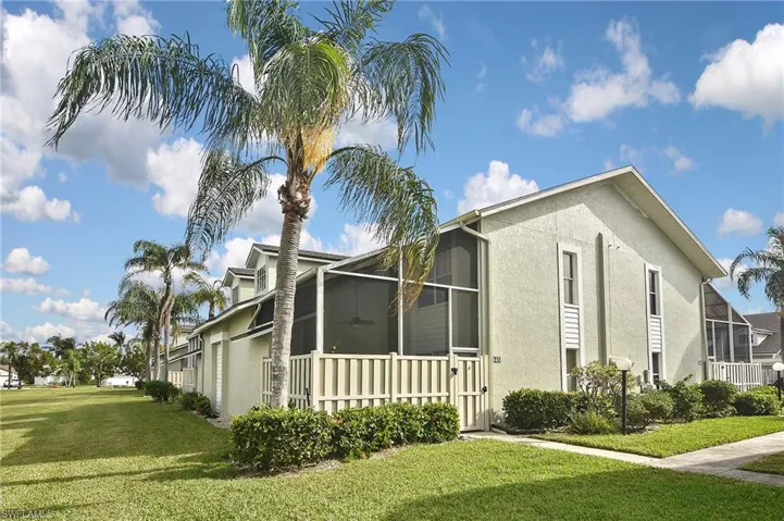 View of property exterior with a sunroom and a lawn