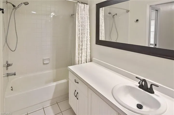 Bathroom featuring vanity, tile patterned floors, and shower / tub combo