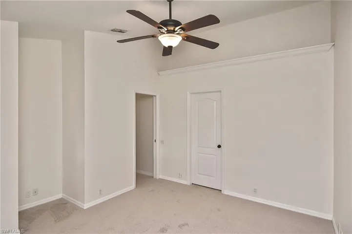 Carpeted empty room with ceiling fan