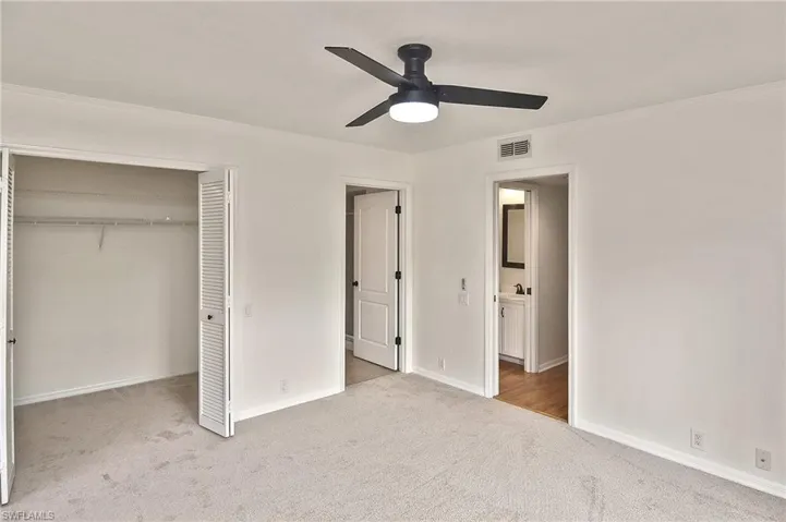 Unfurnished bedroom featuring ceiling fan, light carpet, a closet, and ornamental molding