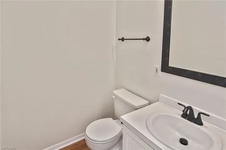 Bathroom featuring toilet, vanity, and wood-type flooring