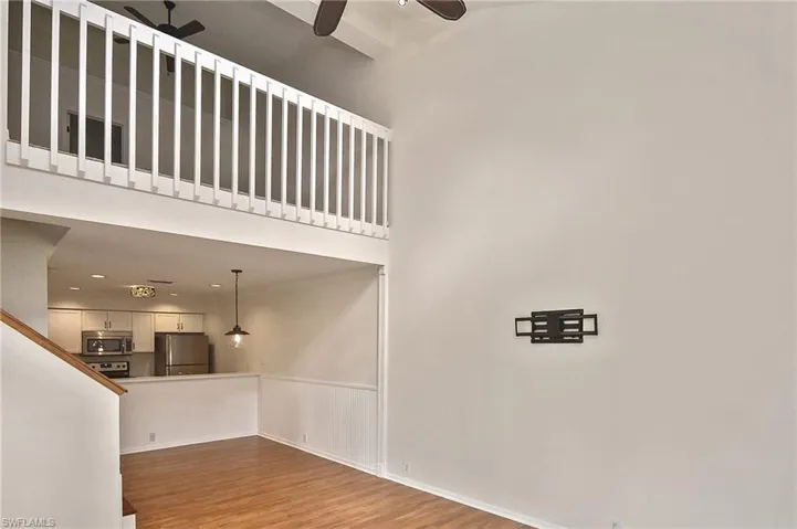 Stairway featuring ceiling fan, hardwood / wood-style flooring, and a high ceiling