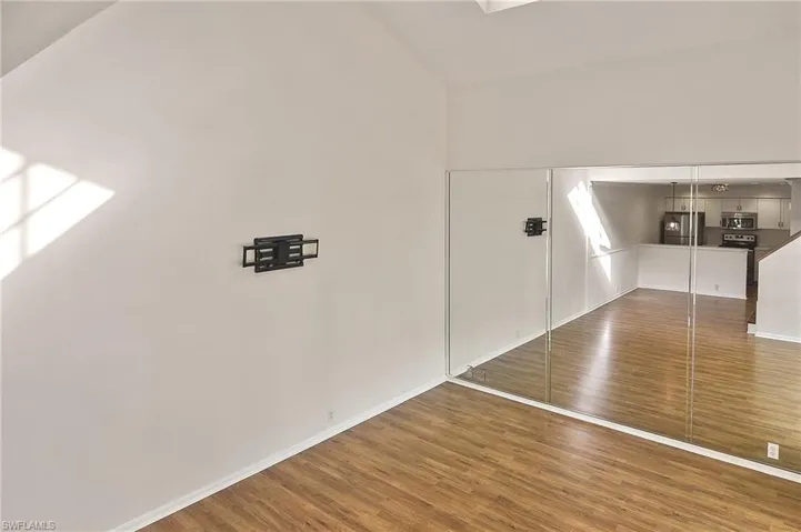 Bonus room featuring hardwood / wood-style floors and lofted ceiling