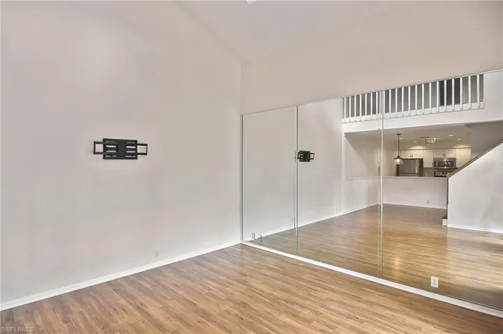 Empty room featuring high vaulted ceiling and hardwood / wood-style flooring