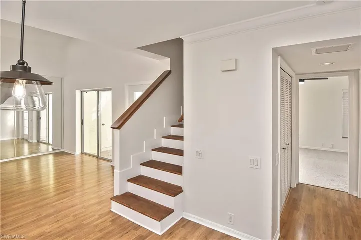 Stairs with ornamental molding and wood-type flooring