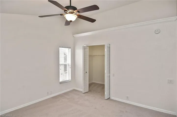 Unfurnished bedroom with light colored carpet, ceiling fan, and a closet