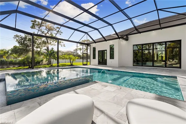 Cool off in the large pool with tanning shelf, a spa, water features & a covered lounge area