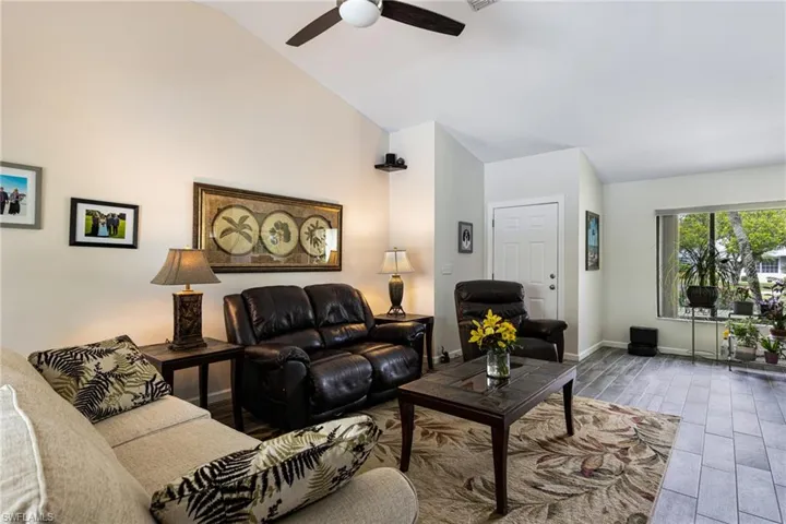 Living room featuring ceiling fan, high vaulted ceiling, and hardwood / wood-style floors