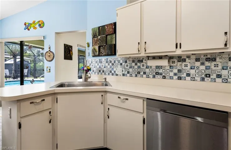 Kitchen with lofted ceiling, dishwasher, and white cabinets