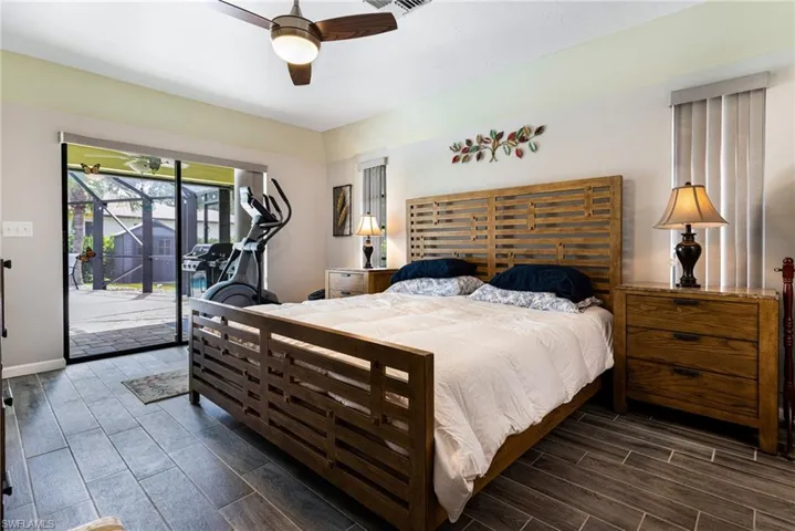 Bedroom featuring ceiling fan, dark hardwood / wood-style flooring, and access to exterior