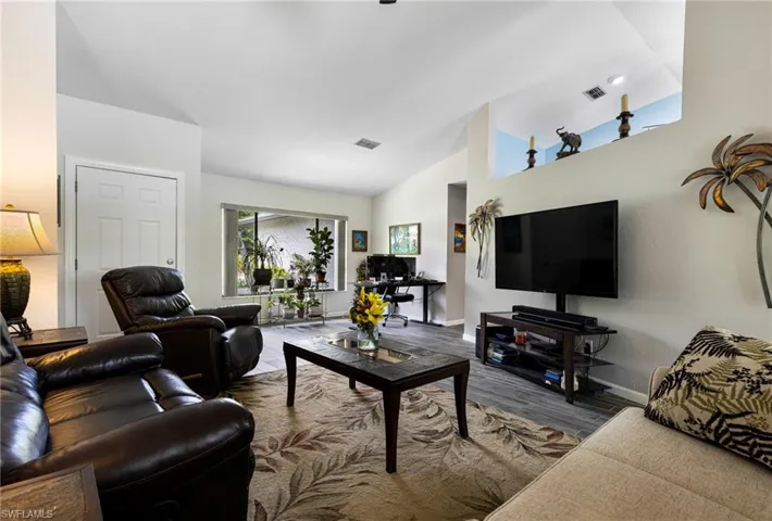 Living room featuring hardwood / wood-style flooring and vaulted ceiling