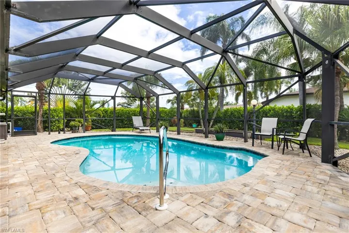 View of pool featuring glass enclosure and a patio area