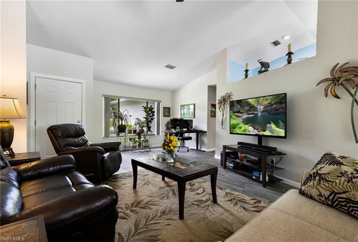 Living room with lofted ceiling and hardwood / wood-style floors