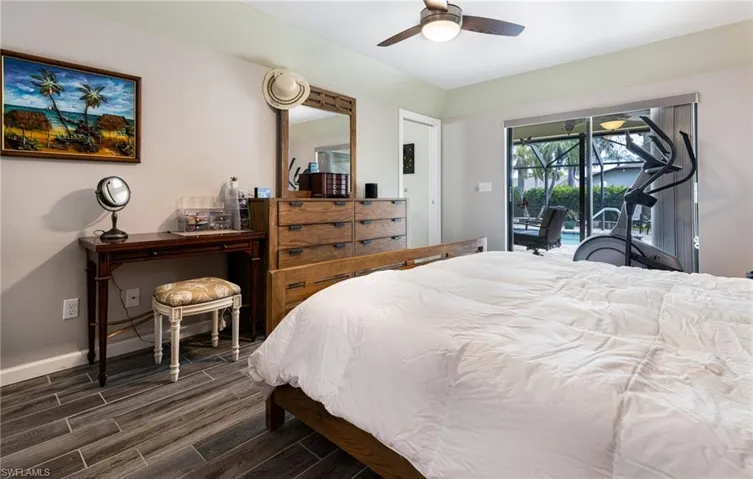 Bedroom with ceiling fan, dark wood-type flooring, and access to exterior