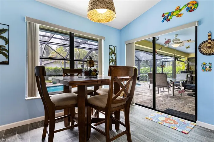 Dining room with wood-type flooring, a healthy amount of sunlight, and lofted ceiling