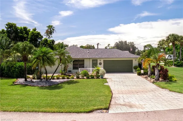 Ranch-style home featuring a front yard and a garage