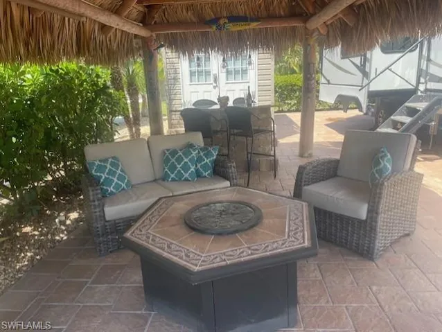 View of patio with a gazebo and an outdoor living space with a fire pit