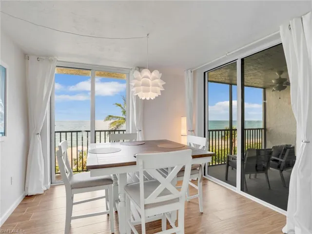 Dining space with a water view, floor to ceiling windows, and light wood-style floors
