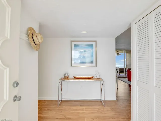 Hallway with light wood-type flooring and recessed lighting