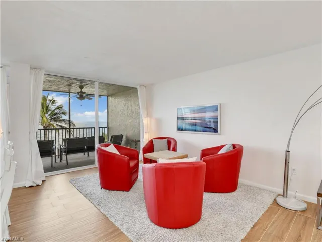 Living area featuring wood finished floors, floor to ceiling windows, and ceiling fan