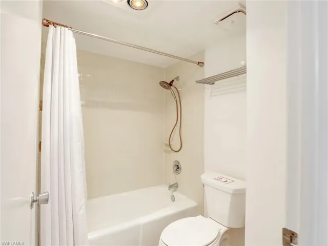 Full bath featuring shower / bath combination with curtain and toilet