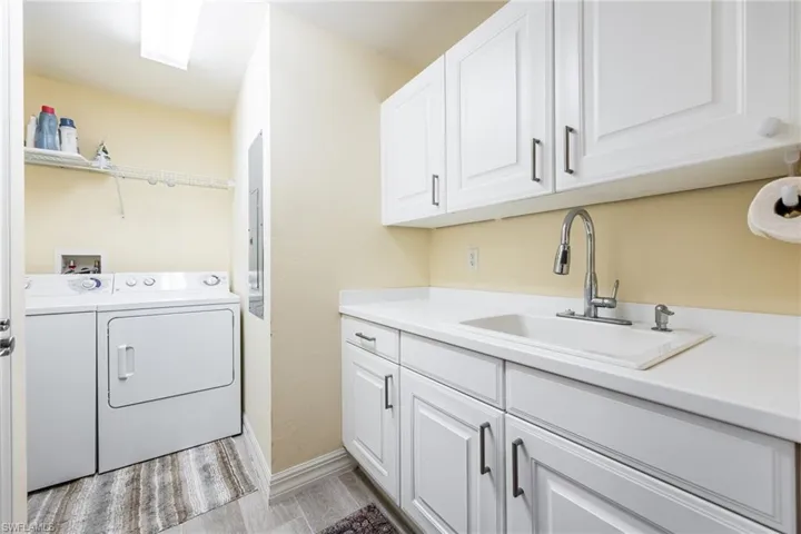 Laundry room featuring sink and plenty of cabinet space.
