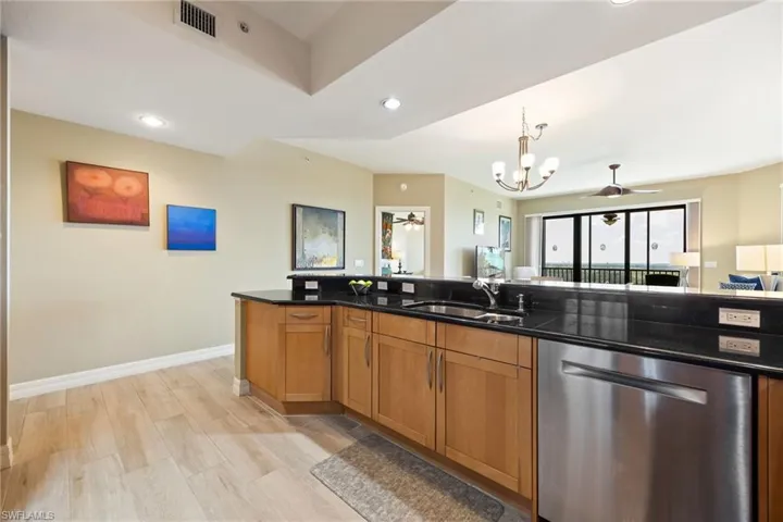Spacious Kitchen with newer dishwasher, and wood-like tile floors.