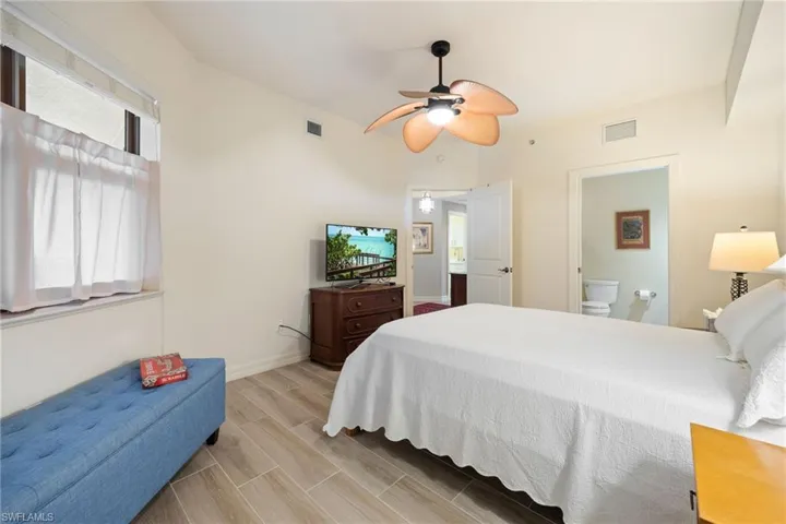 Guest Bedroom with own private bath.  Wood-like tiled floors and ceiling fan.