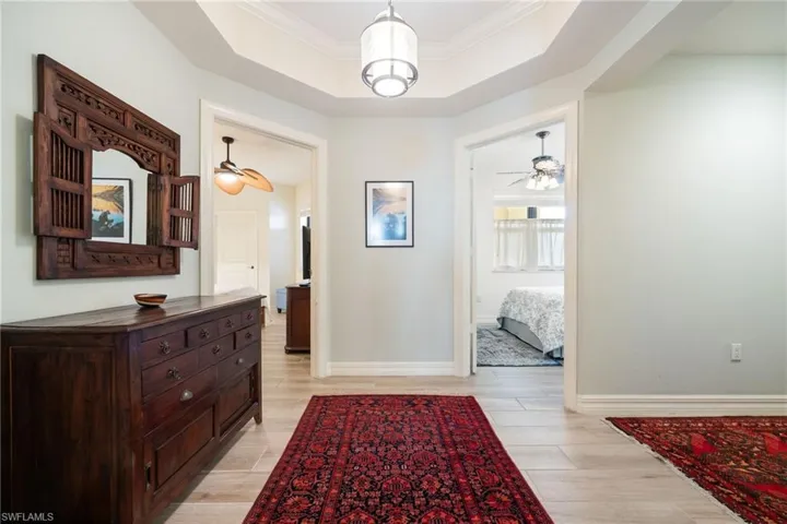 Foyer area with tray ceiling with crown molding, entrance hallway to the right. Front two bedrooms.