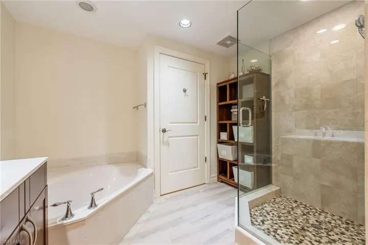 Primary bathroom with a newly redone tile walk-in shower, garden tub with water closet to the side.