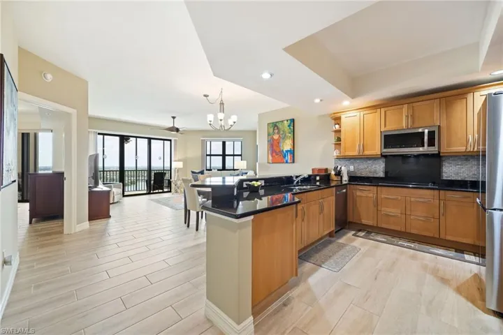 Kitchen with an open floor plan, and wood-like tile floors throughout.